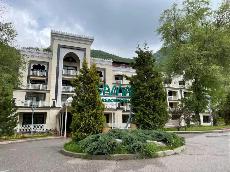 Samal Resort & SPA set against forested mountain foothills above Almaty
